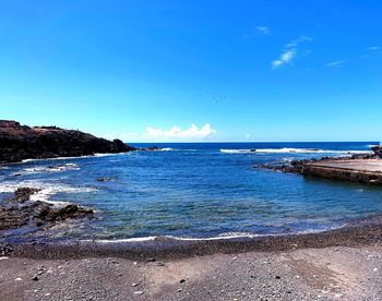 Scenic view of sea against blue sky