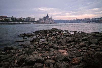 View of rocks on beach against buildings