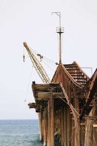 Low angle view of crane against clear sky