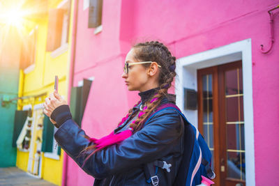 Side view of young man using mobile phone