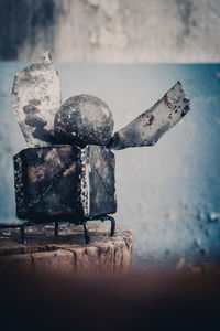 Close-up of rusty metal on table against wall