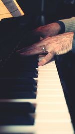 Close-up of hand playing piano