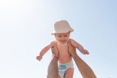 Portrait of shirtless man wearing hat against white background