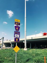Low angle view of road sign against blue sky