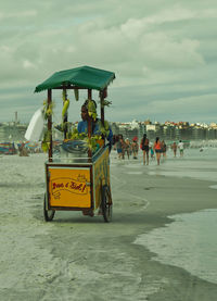 People at beach against sky