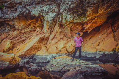 Rear view of man standing on rock formation