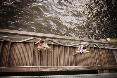 High angle view of friends jogging on steps by river