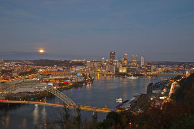 High angle view of city lit up at riverbank