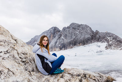 Young millennial girl enjoys the views of the alps standing on glacier