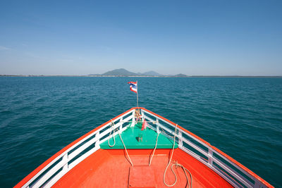 Boat sailing in sea against blue sky