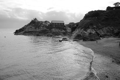 Rock formations on beach against sky