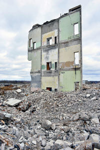 Abandoned building against cloudy sky