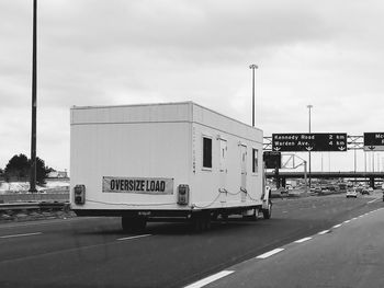 Information sign on road against sky