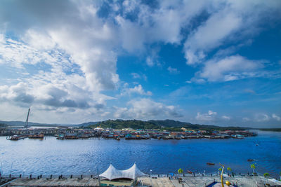 Sailboats moored in sea against sky