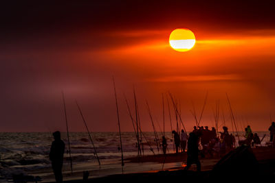 Fishermen with their fishing rods ready to fish on a sunset at the seashore person