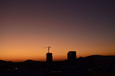 Silhouette buildings against sky during sunset