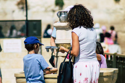 Rear view of people standing outdoors