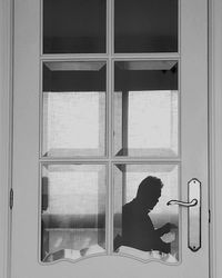 Mature man reflecting on glass door