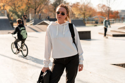 Portrait of young woman standing at park