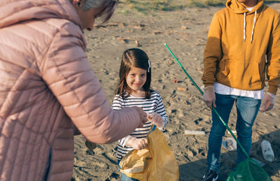 Portrait of girl smiling while standing with family at beach