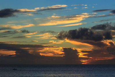 Scenic view of sea against dramatic sky during sunset