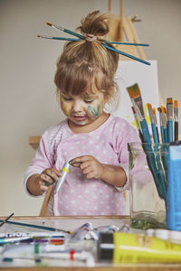 Charming child draws and stains everything with paints