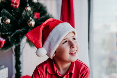 Smiling boy wearing santa hat at home