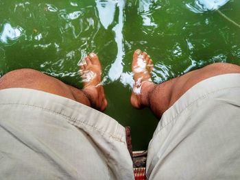 Low section of people relaxing by lake