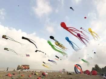 Low angle view of kites flying against sky