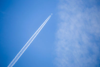 A plane with contrails can be seen in the sky