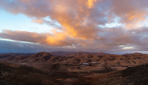 Scenic view of desert against sky during sunset