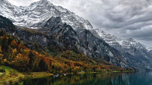 Scenic view of lake by mountains against sky