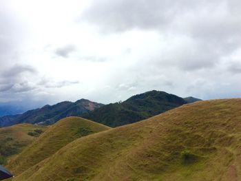 Scenic view of mountains against cloudy sky