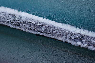 High angle view of frozen windshield wiper