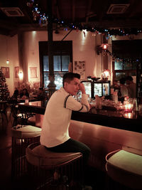 Side view of man sitting in restaurant