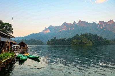 Scenic view of river by mountains against sky