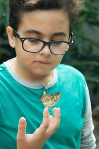 Portrait of boy holding eyeglasses