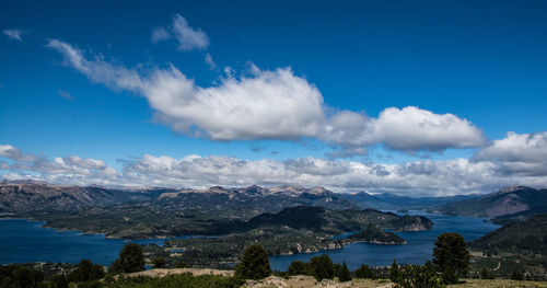 Panoramic view of lake and mountains against blue sky