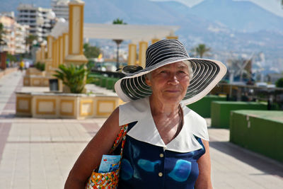 Portrait of smiling senior woman wearing sun hat