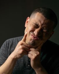 Man making face against black background