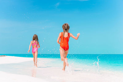 Full length of girl on beach against sky