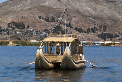 Boat in river against mountains