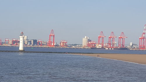 Scenic view of sea by buildings against clear sky