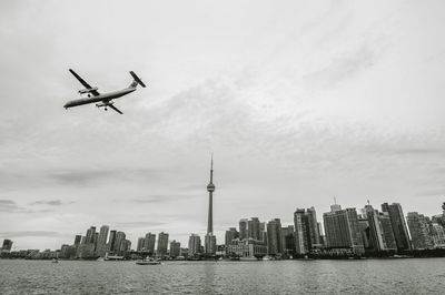 Cranes in city against sky