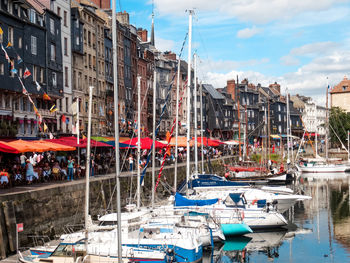 Boats moored at harbor against sky