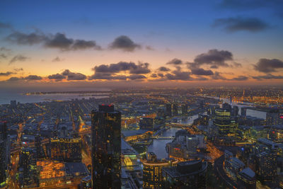 High angle view of city lit up at sunset