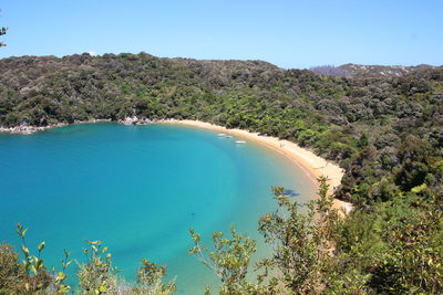 Scenic view of sea and mountains against clear blue sky