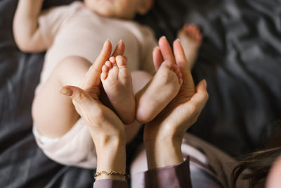 Baby feet in the hands of the mother. tiny legs of a newborn baby on female hands close-up.