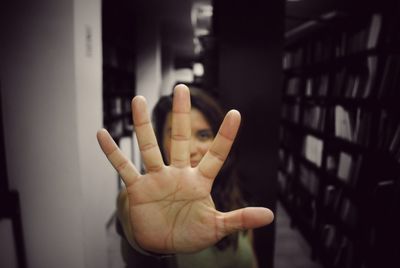 Close-up of woman showing stop gesture in library