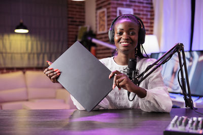 Portrait of young woman using digital tablet at table